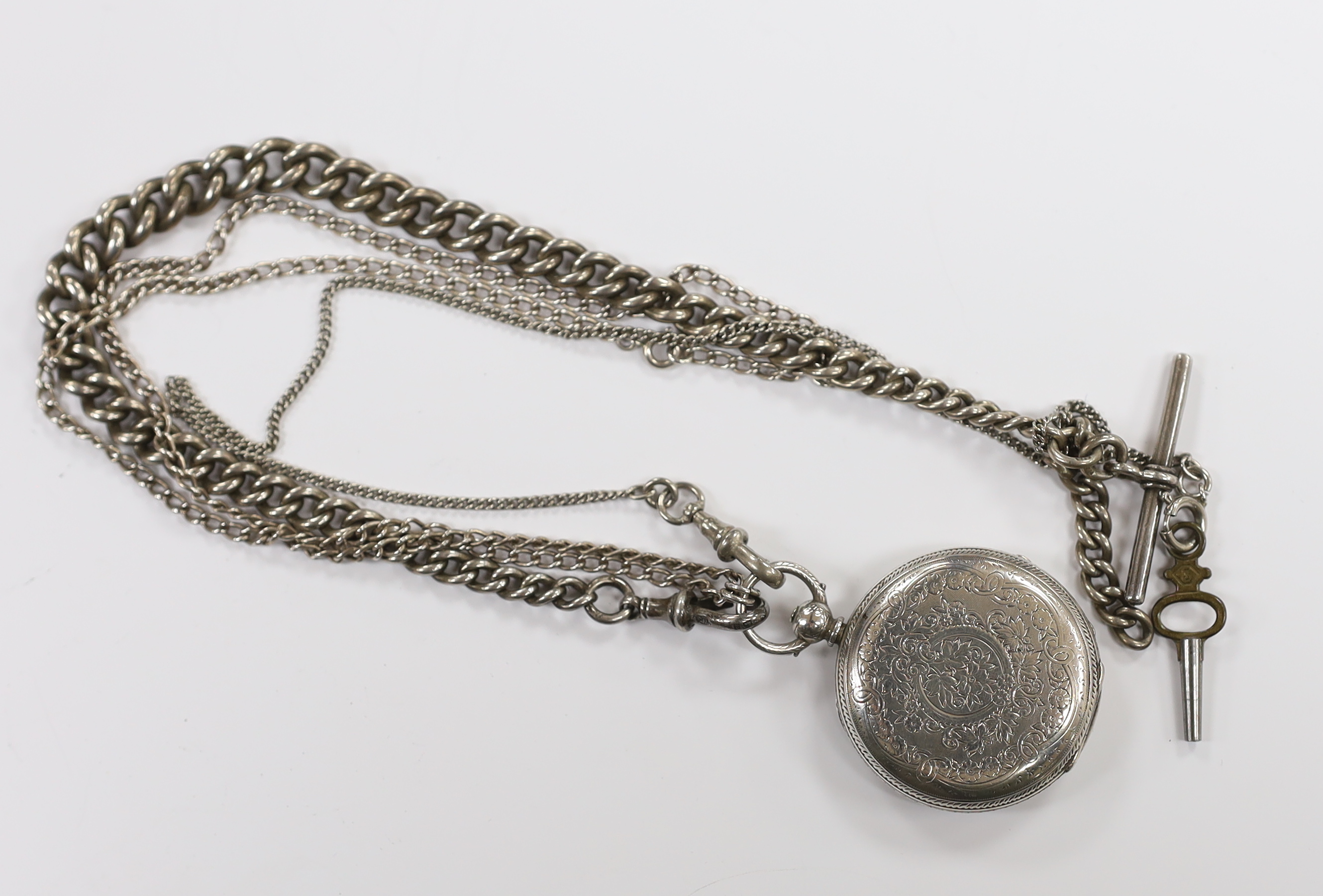 A white metal open face key wind fob watch on a silver albert.